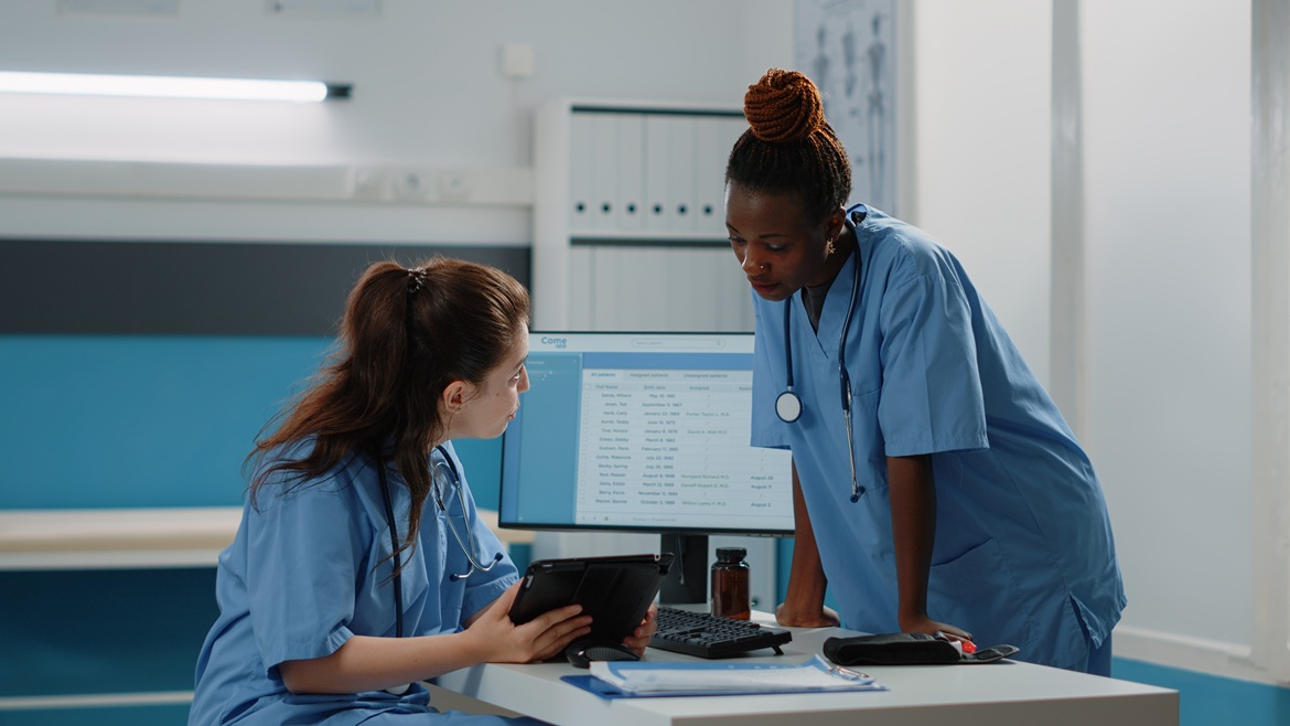 Primary care physician and nursing staff reviewing patient monitoring information during a remote patient monitoring workflow discussion.